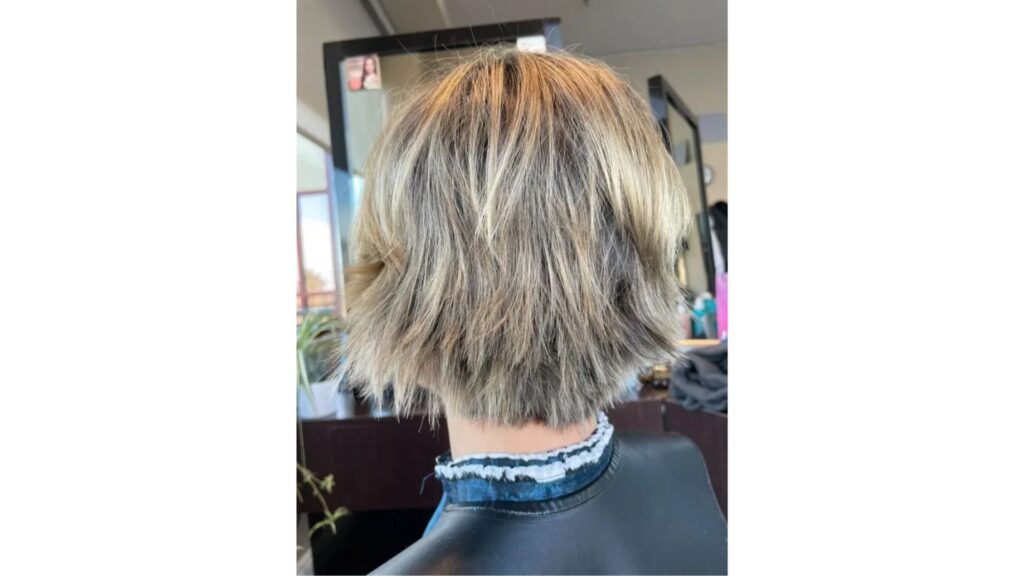 Short layered blonde haircut with textured ends.